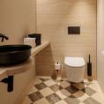 ####Im WC-Bereich des Concept Stores wurde wiederum die Diagonalverlegung von den WCs im Untergeschoss übernommen. Anders dazu wurde hier jedoch auf die beige- und braunfarbenen Travertine Romano Classico und Titanium gesetzt. In handwerklicher Präzision verlegt, ergibt sich somit ein Muster, das Wärme, Natürlichkeit und Wohlbefinden ausstrahlt. Die, in beigem Travertin gehaltene Rückwand, als auch der Waschtisch runden das Gesamtkonzept perfekt ab. Durch die metallische Badezimmerausstattung entsteht ein Kontrast, der sich perfekt in die Farbgebung des Raumes integriert.